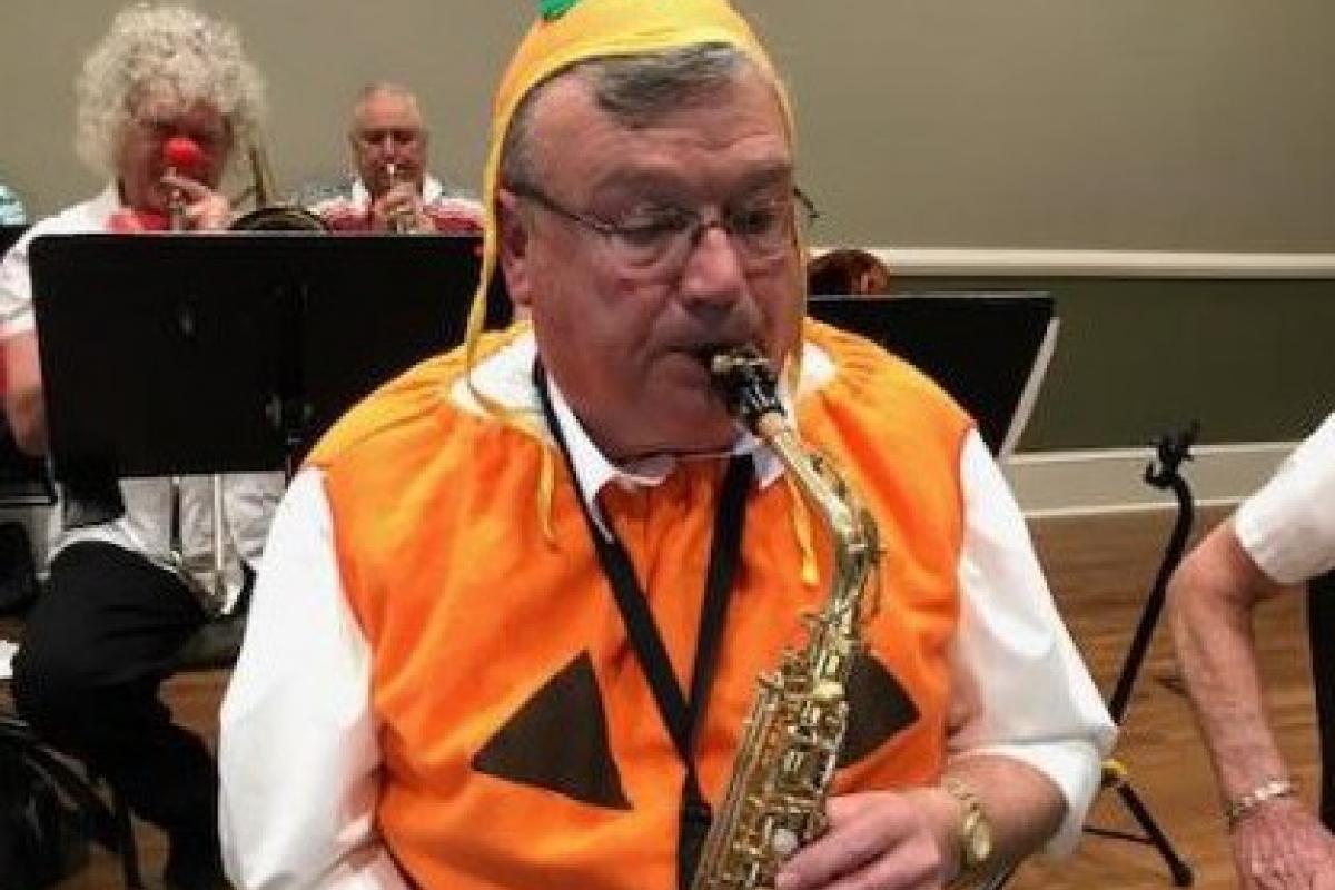 Person in Pumpkin Costume Playing Saxophone